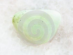 tumbled Prasiolite gemstone on white marble