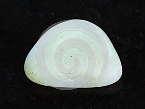 tumbled Prasiolite (green quartz) gemstone on dark