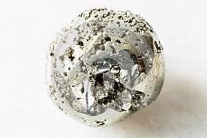 Tumbled Pyrite  fool`s gold rock on white marble