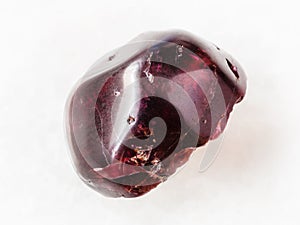 tumbled red garnet gemstone on white