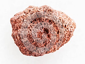 tumbled red pumice pebble on white marble