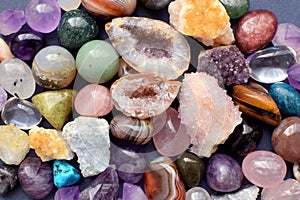 Tumbled and rough gemstones and crystals of various colors. Amethyst, geode amethyst, rose quartz, agate, apatite, aventurine,