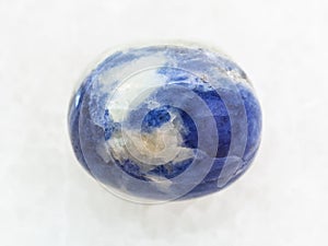 tumbled Sodalite gem stone on white marble