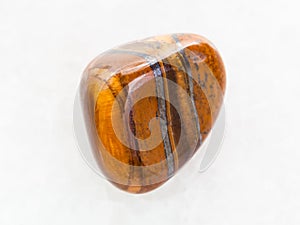 tumbled tigers eye gemstone on white marble