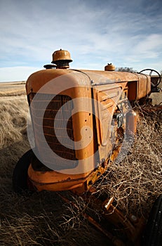 Tumbleweeds piled against abandoned tractor