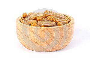 Closeup Turmeric capsules in wood bowl
