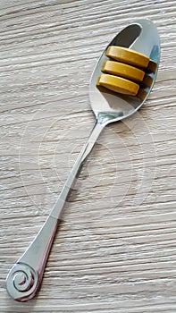 Tumeric tablets on a teaspoon