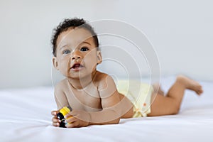 Tummy Time. Cute Black Little Baby Lying On Bed At Home