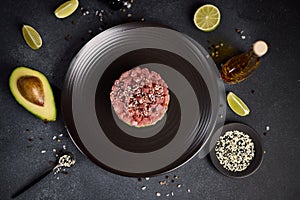 Tuna and avocado tartare on a dark ceramic plate