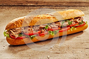 Tuna fish and salad baguette on wood