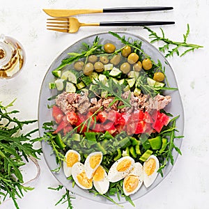 Tuna fish salad with eggs, cucumber, tomatoes, olives and arugula.