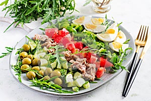 Tuna fish salad with eggs, cucumber, tomatoes, olives and arugula.