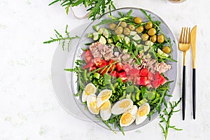 Tuna fish salad with eggs, cucumber, tomatoes, olives and arugula.