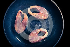 Tuna fish with spices fried on black pan. Toned