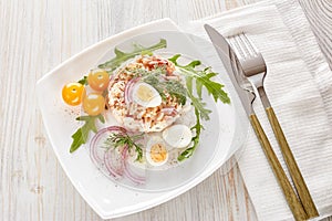 Tuna salad with rice, arugula and tomatoes on light wooden background. Healthy food, seafood menu