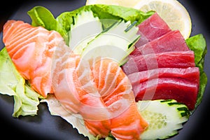 Tuna and salmon sashimi on black dish