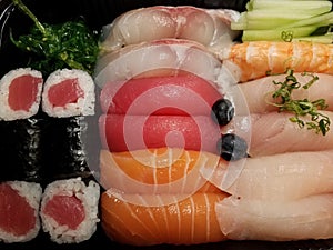 tuna and salmon sushi with blueberries in container