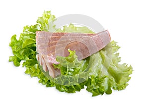 Tuna slices isolated on white background close up with green lettuce