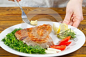 Tuna steak cooked on the electric grill. tunafish served on a plate with fresh herbs and vegetables. healthy nutritious