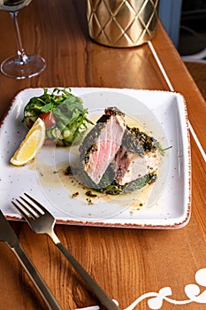 Tuna Steak Fillet with Spinach and Fresh Vegetables on a Table