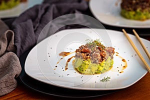 Tuna tartan on white plate serced with soja and chopsticks photo