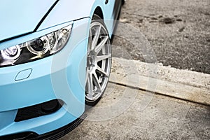 Tuned car headlight detail. Macro view of modern blue car
