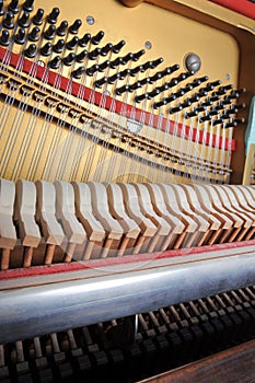 Tuner inside of a piano with little hammer