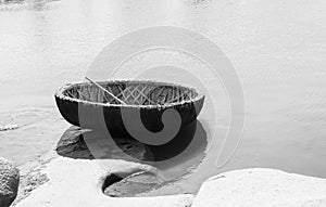 Tungabhadra River at Hampi. In the foreground is a round boat in monochrome.