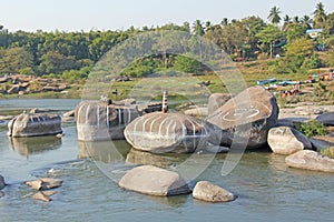 Tungabhadra river in the village of Hampi. Big stone. Tropical exotic landscape. Beautiful green valley. View from above