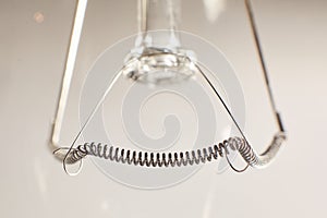 Tungsten filament in incandescent lamp, macro close-up