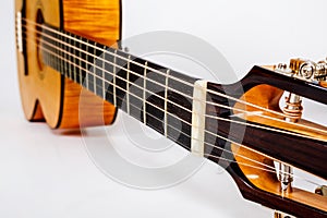 Tuning pegs on wooden machine head of six strings guitar on white background