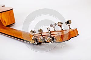 Tuning pegs on wooden machine head of six strings guitar on white background