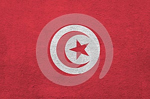 Tunisia flag depicted in bright paint colors on old relief plastering wall. Textured banner on rough background