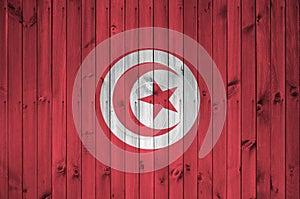 Tunisia flag depicted in bright paint colors on old wooden wall. Textured banner on rough background