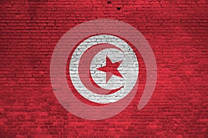 Tunisia flag depicted in paint colors on old brick wall. Textured banner on big brick wall masonry background