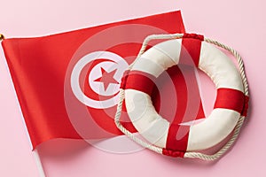 Tunisian flag and lifebuoy on a colored background, concept on the theme of helping Tunisia