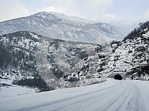 Tunnel in front of road in winter mountain landscape, Norway