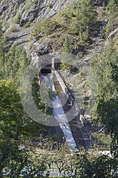 Tunnel and gutter of the Malaya Almatinka river discharge through the body of the mudflow protection dam in Medeo