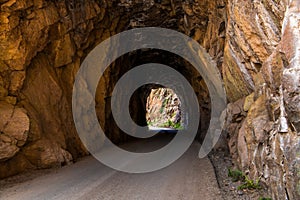 Tunnel and road curving through red rock sandstone
