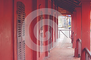 Tunnel walkway or footpath in old red buildings.