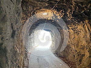 Tunnels through the cliffs at the foot of the Churfirsten mountain range on the road along the shore of Lake Walen or Walensee