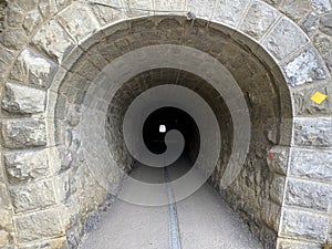 Tunnels through the cliffs at the foot of the Churfirsten mountain range on the road along the shore of Lake Walen or Walensee