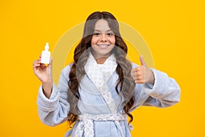 Tunny nose and allergy, nasal spray. Teen girl in pajama use nasal drops, stuffed nose  on yellow background.