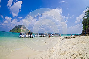 TUP, THAILAND - FEBRUARY 09, 2018: Amazing view of unidentified people in the beach close to a long tail boats in a row