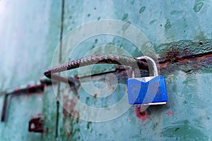 Tuquoise blue aged destroyed weathered metal surface door, blue padlock, green rain drop dots, background texture, copy space photo