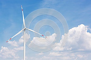 Turbine generator against the blue sky with clouds, alternative wind energy concept