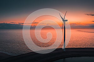Turbine by the sea with the breathtaking colorful sky in the background