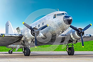 Turbo-prop vintage airplane parked at the airport, shiny metal fuselage aircraft. photo