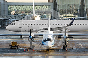 Turboprop aircraft parked behind the jet plane taxiing