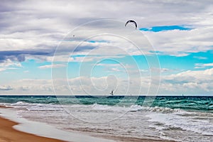 Turbulent sea with wind surfer catching air and helicopter overhead and sailboats on horizon off Gold Coast in Queensland